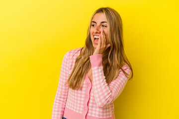 Young blonde caucasian woman isolated on yellow background shouting excited to front.