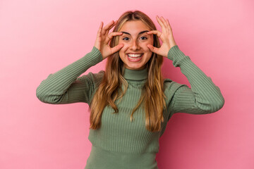 Young blonde caucasian woman isolated on pink background keeping eyes opened to find a success opportunity.