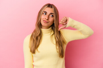 Young blonde caucasian woman isolated on pink background showing a dislike gesture, thumbs down. Disagreement concept.