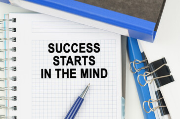 Among the documents, folders, a notebook with the inscription - SUCCESS STARTS IN THE MIND