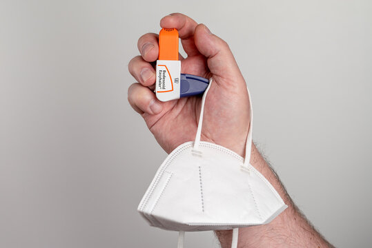 Budesonid Easyhaler in a hand and a FFP2 face mask. For chronic bronchitis, asthma and, according to the latest findings, for COVID-19, SARS-CoV-2 infection	