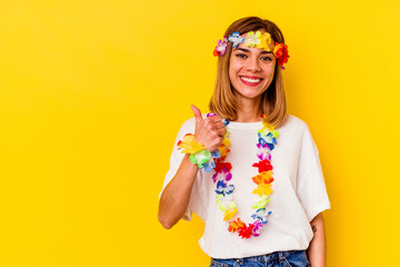 Young caucasian woman celebrating a hawaiian party isolated on yellow background smiling and...