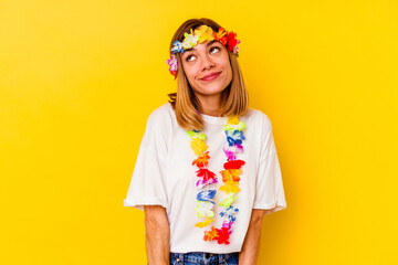 Young caucasian woman celebrating a hawaiian party isolated on yellow background dreaming of achieving goals and purposes
