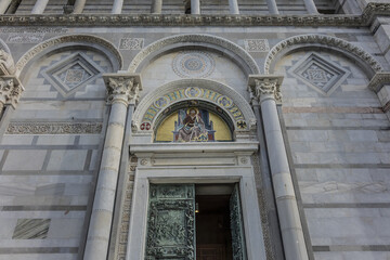 Architectural fragments of Romanesque medieval Roman Catholic Pisa Cathedral at Square of Miracles (Piazza dei Miracoli or Piazza del Duomo), UNESCO World Heritage Site. Pisa, Tuscany, Italy.