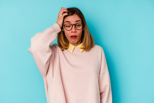 Young student caucasian woman isolated on blue background tired and very sleepy keeping hand on head.
