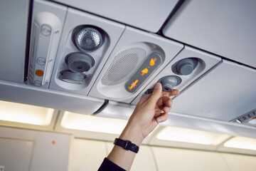man hand regulates the air and light in the plane on the instrument panel above