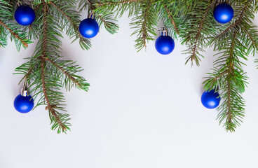 Christmas Border - Fir Branches And Ornament with blue balls on white background. Christmas wallpaper, winter festive composition, new year concept. Flat lay, top view, copy space for your text. 
