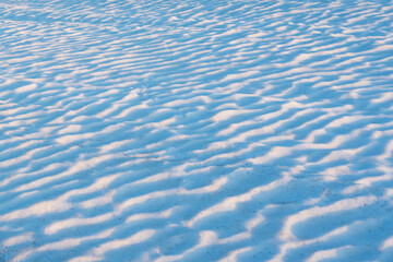 Beautiful bluish snow waves on the field.