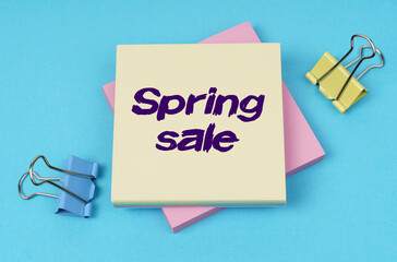 On the table are paper clips, note paper with text - Spring sale