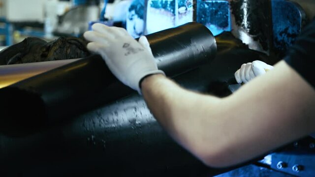 Worker cut rubber sheet from industrial roller 4K