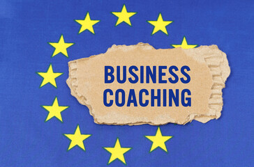 There is a cardboard box on the EU flag that says- BUSINESS COACHING