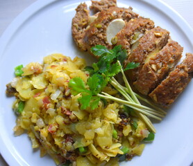 Mit Ei gefüllter Hackbraten neben goldgelben Bratkartoffeln