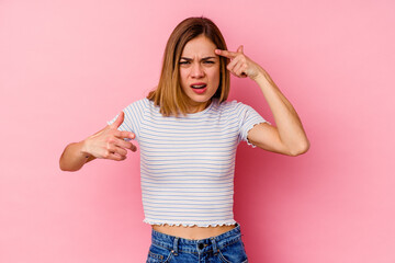 Young caucasian woman isolated on pink background showing a disappointment gesture with forefinger.