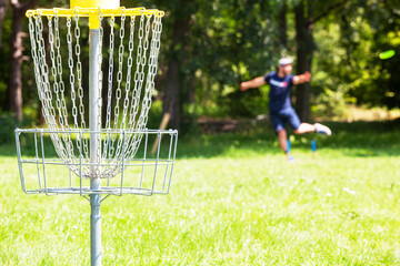 Man playing flying disc golf sport game in the city park or nature
