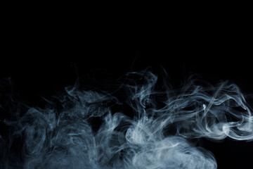 Abstract white smoke moves on black background. Beautiful swirling gray smoke.