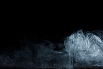 Abstract white smoke moves on black background. Beautiful swirling gray smoke.