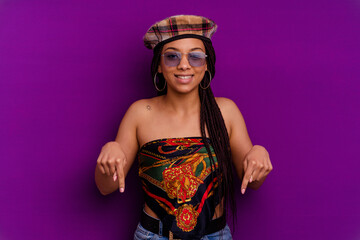 Young african american woman isolated on yellow background Young african american woman isolated on yellow background points down with fingers, positive feeling.