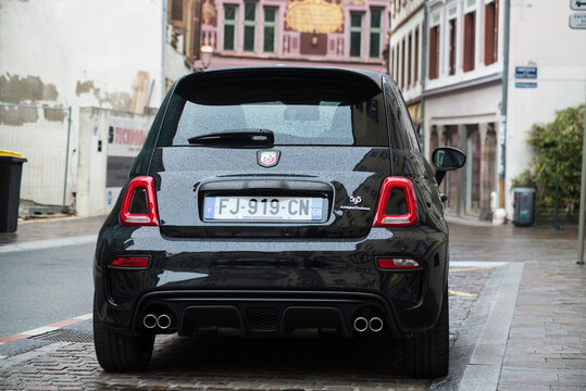 Mulhouse - France - 18 April 2021 - Rear view of black Abarth 595 parked in the street by rainy day
