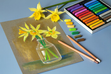 Soft pastel painting at home. Wonderful bouquet of daffodils, painted in pastel on paper. Colored pastels set. 