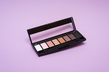 palette of basic eyeshadows on a purple background. Makeup concept