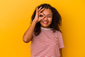 Young african american woman isolated on yellow background excited keeping ok gesture on eye.