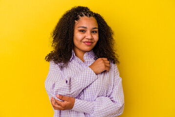 Young african american woman isolated on yellow background massaging elbow, suffering after a bad movement.