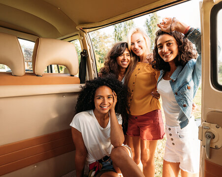 Multi-ethnic group of female friends spending time together at camper van