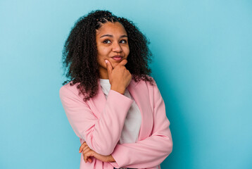 Obraz premium Young african american woman isolated on blue background thinking and looking up, being reflective, contemplating, having a fantasy.