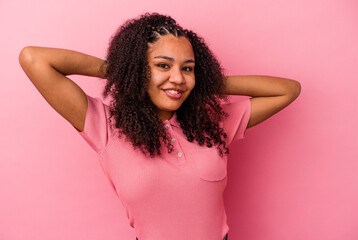 Young african american woman isolated on pink background feeling confident, with hands behind the head.