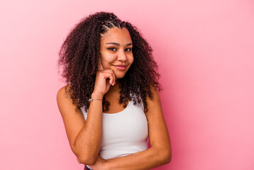 Young african american woman isolated on pink background smiling happy and confident, touching chin with hand.