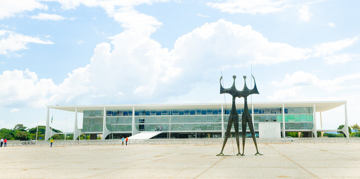 Pal&aacute;cio do Planalto e a escultura "Os Candangos" ou "Os Guerreiros" na Pra&ccedil;a dos Tr&ecirc;s poderes na capital federal brasileira. Dois Guerreiros" Bras&iacute;lia, Distrito Federal - Brasil. 18 de Abril de 2021.