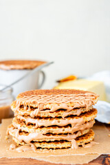 Traditional local authentic Dutch Netherlands sweet fresh homemade tasty stack brown golden waffle melt salted caramel honey syrup for dessert in cafe with hot warm coffee milk tea call Stroopwafel