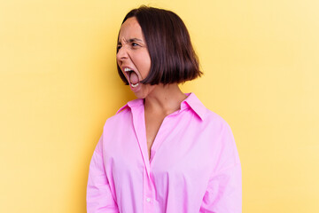 Fototapeta premium Young mixed race woman isolated on yellow background shouting towards a copy space