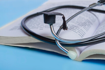 medical education. stethoscope, book and graduate hat. medical concept on blue background. graduate