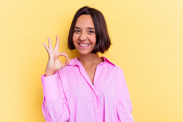 Young mixed race woman isolated on yellow background cheerful and confident showing ok gesture.