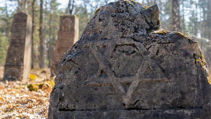 Unique Wooden Jewish matzevah. Jewish Tombstone. Old jewish cemetery in the forest.