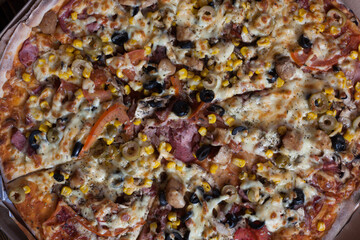 delicious homemade pizza with corn, meat, tomatoes, mushrooms and cheese. Pizza up close. 

