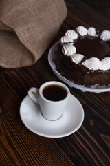 A mug of aromatic coffee on a wooden table with dessert. Coffee break. Chocolate cake. 