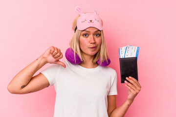 Young venezuelan traveler woman holding a passport isolated on pink background feels proud and self confident, example to follow.