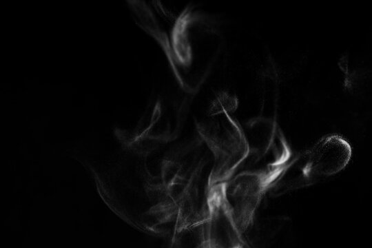 Real photo of white steam smoke on isolate solid black background with abstract blur motion wave swirl use as an overlay effect for vapor cigarette dry ice hot food soup tea coffee 