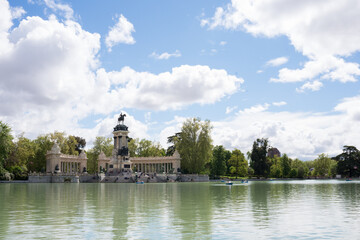 Fototapeta na wymiar Lake at Retiro park, Madrid, on a sunny day. Some boats and people in the distance