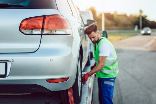 Handsome middle age man working in towing service on the road. Roadside assistance concept.
