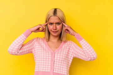 Young venezuelan woman isolated on yellow background focused on a task, keeping forefingers pointing head.
