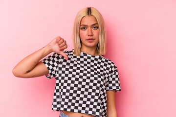 Young venezuelan woman isolated on pink background showing a dislike gesture, thumbs down. Disagreement concept.