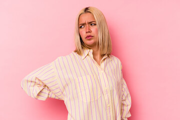 Young venezuelan woman isolated on pink background suffering a back pain.