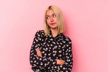 Young venezuelan woman isolated on pink background dreaming of achieving goals and purposes