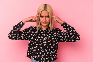 Young venezuelan woman isolated on pink background focused on a task, keeping forefingers pointing head.