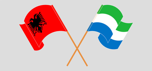 Crossed and waving flags of Albania and Sierra Leone