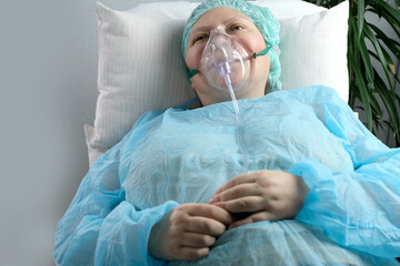 female patient in blue shirt lies, woman with facial oxygen mask, concept of medical care,...