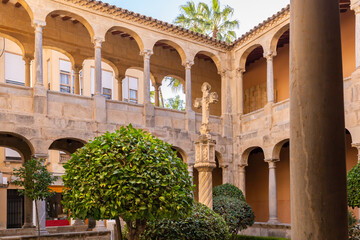 Obraz premium The courtyard of the Monastery of the Sacred Cathedral of El Salvador with a stone cross in the city of Orihuela on the Costa Blanca in Spain